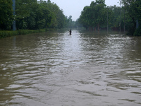 A man takes a selfie as he wades through the flooded carriageway of a road, after a rise in the waters of the river Yamuna due to heavy mons...