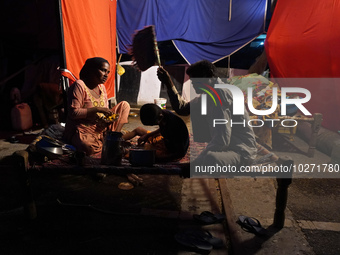 A family eats food outside a makeshift tent as they take shelter on an under-construction flyover, after a rise in the waters of river Yamun...