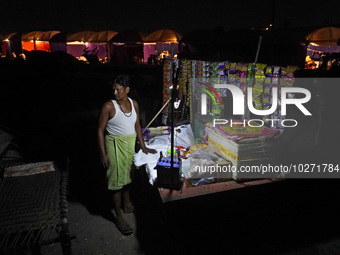 A man stands at his temporary shop set-up near the makeshift tents for evacuated residents on an elevated road, after a rise in the waters o...