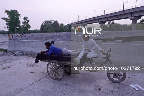 Men rest on a rickshaw near the makeshift tents for evacuated residents on an under-construction flyover, after a rise in the waters of rive...