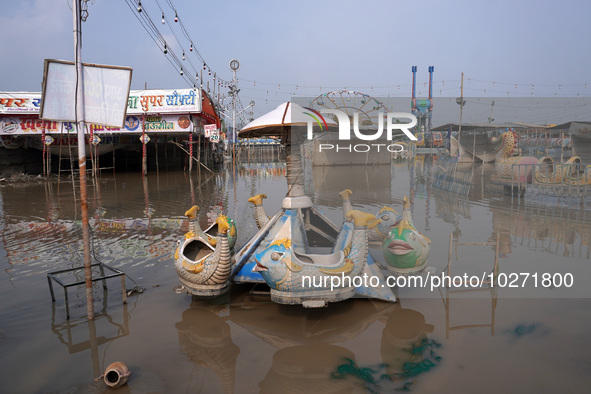 A swing is seen inside a flooded fair ground in a low-lying area, after a rise in the waters of river Yamuna due to heavy monsoon rains, in...