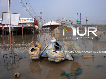 A swing is seen inside a flooded fair ground in a low-lying area, after a rise in the waters of river Yamuna due to heavy monsoon rains, in...