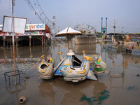 A swing is seen inside a flooded fair ground in a low-lying area, after a rise in the waters of river Yamuna due to heavy monsoon rains, in...