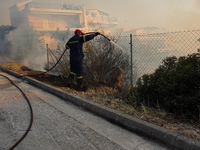 Fireman is fighting the fire  during a wildfire in southern urban of Attica, Greece, on 17, July 2023. Fire fighting forces battling a blaze...