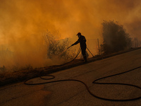 Fireman is fighting the fire  during a wildfire in southern urban of Attica, Greece, on 17, July 2023. Fire fighting forces battling a blaze...