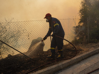 Fireman is fighting the fire  during a wildfire in southern urban of Attica, Greece, on 17, July 2023. Fire fighting forces battling a blaze...