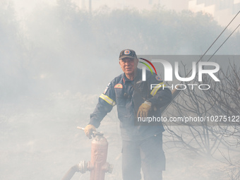 Fireman is fighting the fire  during a wildfire in southern urban of Attica, Greece, on 17, July 2023. Fire fighting forces battling a blaze...