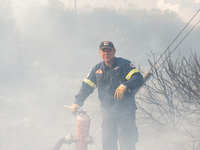 Fireman is fighting the fire  during a wildfire in southern urban of Attica, Greece, on 17, July 2023. Fire fighting forces battling a blaze...