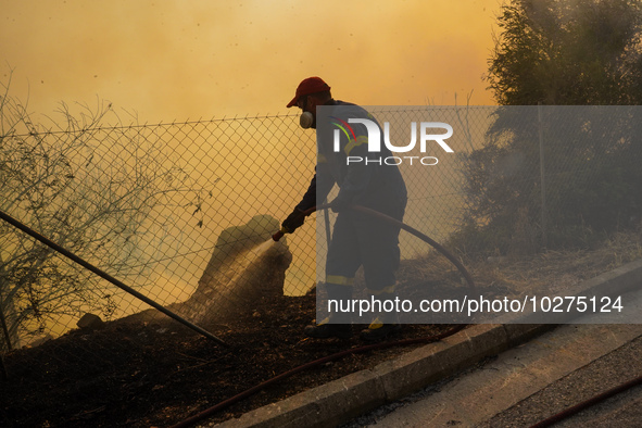 Fireman is fighting the fire  during a wildfire in southern urban of Attica, Greece, on 17, July 2023. Fire fighting forces battling a blaze...