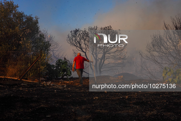 Residents fighting the fire  during a wildfire in southern urban of Attica, Greece, on 17, July 2023. Fire fighting forces battling a blaze...