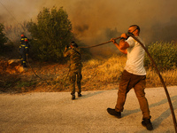 Fire during a wildfire in southern urban of Attica, Greece, on 17, July 2023. Fire fighting forces battling a blaze that broke out on Monday...