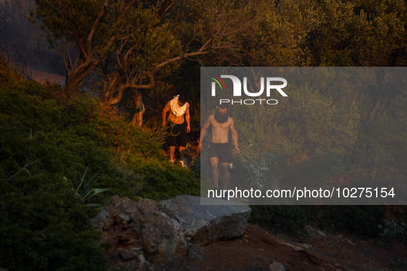 Residents fighting the fire  during a wildfire in southern urban of Attica, Greece, on 17, July 2023. Fire fighting forces battling a blaze...