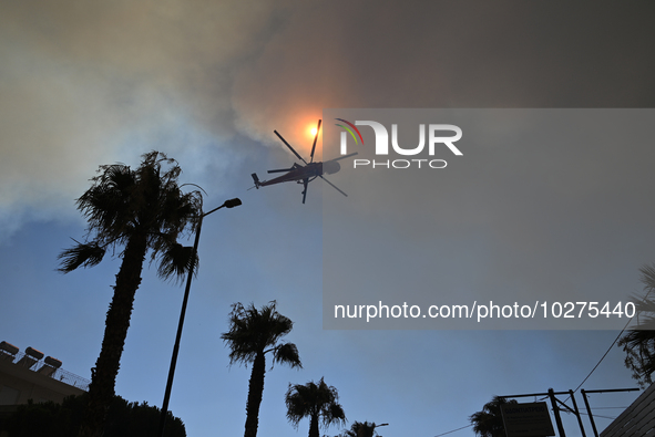 A firefighting helicopter operates in Saronida near Athens, Greece on July 17, 2023. 