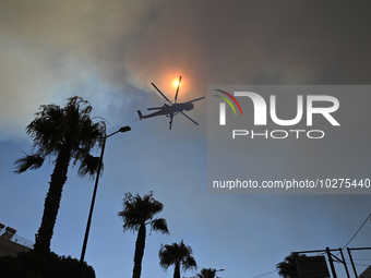 A firefighting helicopter operates in Saronida near Athens, Greece on July 17, 2023. (