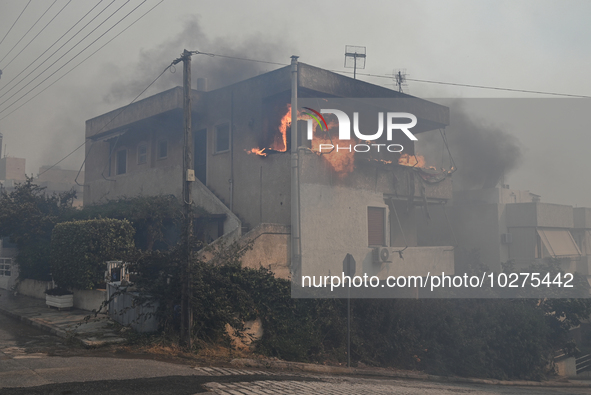 Flames engulf a house  as a wildfire rages in Saronida near Athens, Greece on July 17, 2023. 