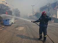 A firefighter operates  as a wildfire rages inside the residential area of Saronida near Athens, Greece on July 17, 2023. (