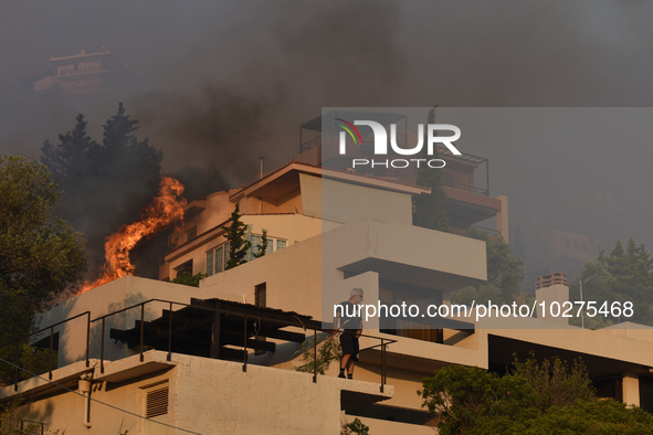 Flames engulf a house  as a wildfire rages in Saronida near Athens, Greece on July 17, 2023. 