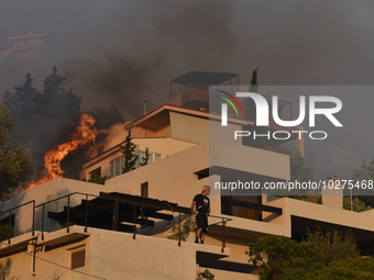 Flames engulf a house  as a wildfire rages in Saronida near Athens, Greece on July 17, 2023. (