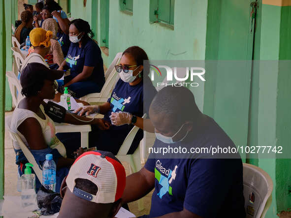 People are seen with medical health workers during a free medical outreach by LFC Jahi at Mpape, Abuja, on july 18, 2023.  