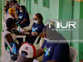 People are seen with medical health workers during a free medical outreach by LFC Jahi at Mpape, Abuja, on july 18, 2023.  (