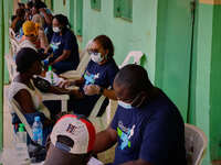 People are seen with medical health workers during a free medical outreach by LFC Jahi at Mpape, Abuja, on july 18, 2023.  (