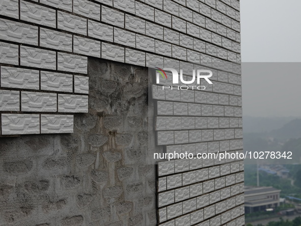 

Tiles are falling off the exterior wall of a high-rise residential building in Yichang, Hubei province, China, on July 19, 2023. With the...