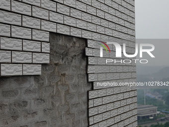 

Tiles are falling off the exterior wall of a high-rise residential building in Yichang, Hubei province, China, on July 19, 2023. With the...