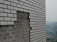 

Tiles are falling off the exterior wall of a high-rise residential building in Yichang, Hubei province, China, on July 19, 2023. With the...