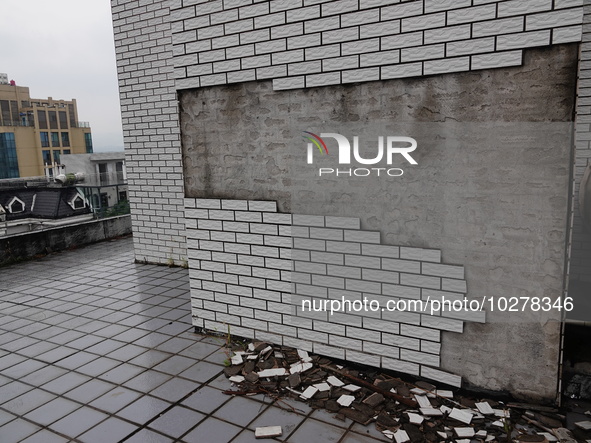 

Tiles are falling off the exterior wall of a high-rise residential building in Yichang, Hubei province, China, on July 19, 2023. With the...