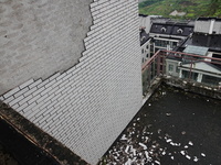 

Tiles are falling off the exterior wall of a high-rise residential building in Yichang, Hubei province, China, on July 19, 2023. With the...