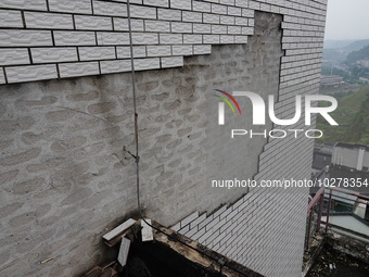 

Tiles are falling off the exterior wall of a high-rise residential building in Yichang, Hubei province, China, on July 19, 2023. With the...