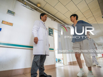 Medical staff encourage patients to keep exercising at the Third People's Hospital in Bijie, Southwest China's Guizhou province, July 13, 20...