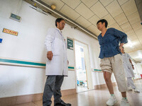 Medical staff encourage patients to keep exercising at the Third People's Hospital in Bijie, Southwest China's Guizhou province, July 13, 20...