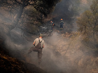 

Firefighters are trying to extinguish a wildfire in Nea Zoi, Nea Peramos, near Megara, Greece on July 19, 2023. After three days, firefigh...