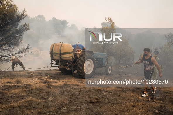 

Locals are helping firefighters to extinguish the fire in Nea Zoi in Nea Peramos, a place near Megara, Greece on July 19, 2023. After thre...