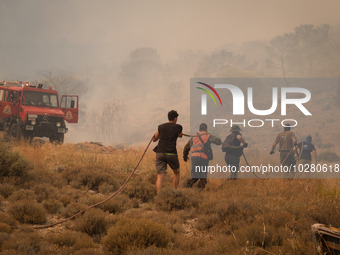 

Locals are helping firefighters to extinguish the fire in Nea Zoi in Nea Peramos, a place near Megara, Greece on July 19, 2023. After thre...