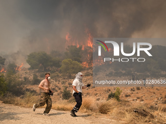 

Locals are helping firefighters to extinguish the fire in Nea Zoi in Nea Peramos, a place near Megara, Greece on July 19, 2023. After thre...