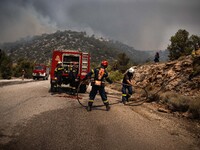 

Athens, Greece, on July 18th, 2023, Greek firefighters are trying to hold their position, blocking the flames from proceeding from Derveno...