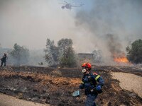 

Athens, Greece, on July 18th, 2023, helicopters and ground units are struggling to contain the flames at the Dervenohoria wildfire front....