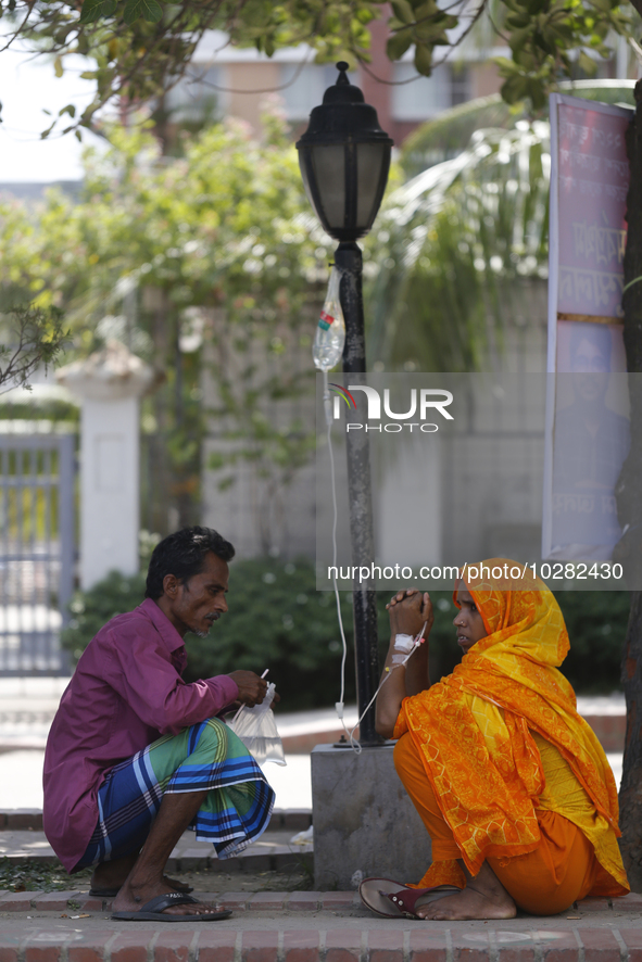 A woman suffering from dengue fever takes a rest under the tree at a government hospital in Dhaka, Bangladesh on July 20. 2023. More than 10...