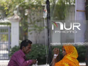 A woman suffering from dengue fever takes a rest under the tree at a government hospital in Dhaka, Bangladesh on July 20. 2023. More than 10...