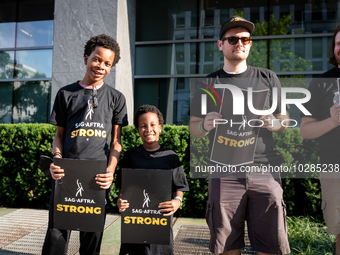 Malachi (left) and Kendrick White picket a Barbie screening with SAG-AFTRA actors and other union members.  The two brothers, ages 13, and 6...