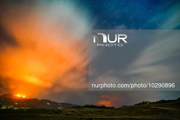 A mountain wildfire and milky way seen from a Teldeniya old town in Kandy, Sri Lanka, on July  22, 2023 