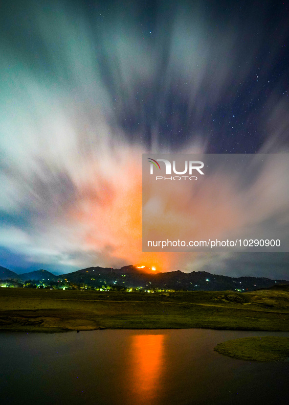 A mountain wildfire and milky way seen from a Teldeniya old town in Kandy, Sri Lanka, on July  22, 2023 