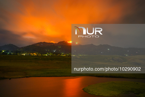 A mountain wildfire and milky way seen from a Teldeniya old town in Kandy, Sri Lanka, on July  22, 2023 