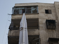 A man raise curtains to the top of the building  on Bustan Alqasr district in Aleppo city on 1st February 2016.
(