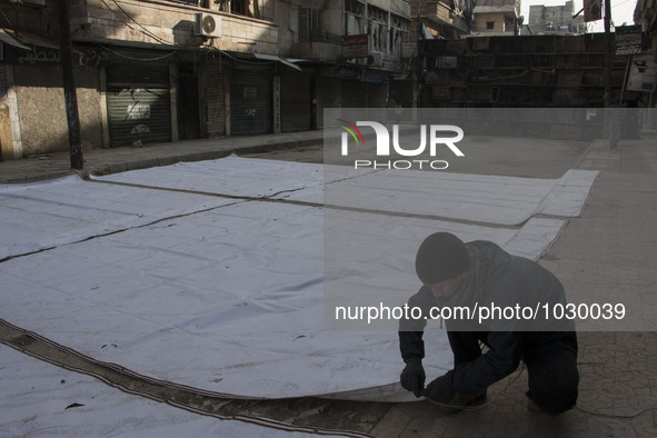 A man prepares curtains before raise it  on Bustan Alqasr district in Aleppo city on 1st February 2016.
