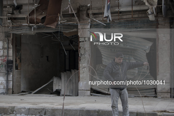 A man prepares a rope to raise the curtains  on Bustan Alqasr district in Aleppo city on 1st February 2016.
