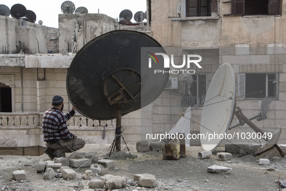 two men are tieding ropes curtains  on Bustan Alqasr district in Aleppo city on 1st February 2016.
