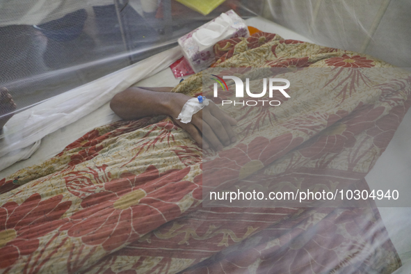 A dengue-infected patient lays down with a blanket stay under mosquito at Shaheed Suhrawardy Medical College and Hospital in Dhaka, Banglade...